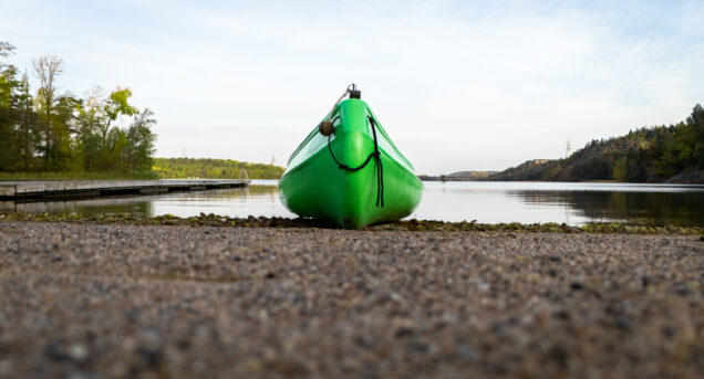 En kanot sedd framifrån vid strandkanten av en sjö